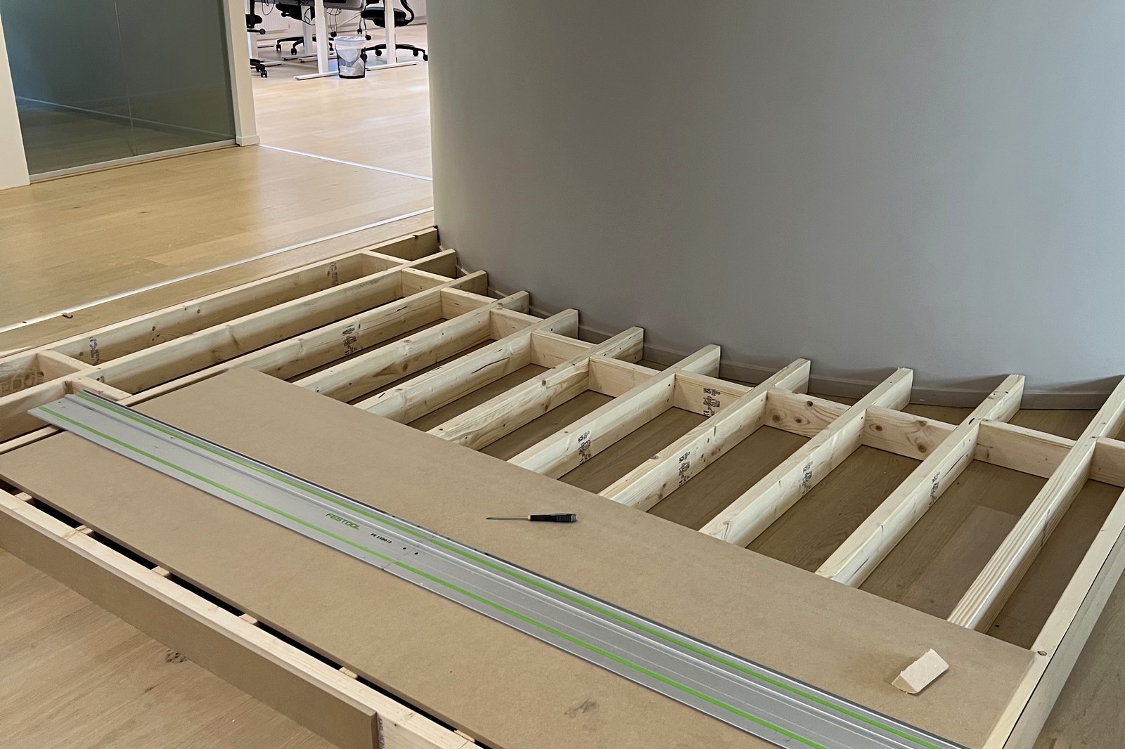 Platsbyggd regelstomme till scenpodium i kontorslandskap